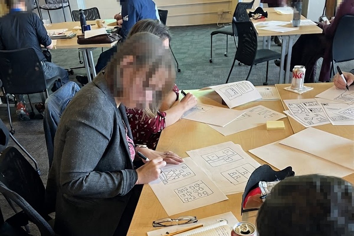 People sketching their apps on paper at a workshop table