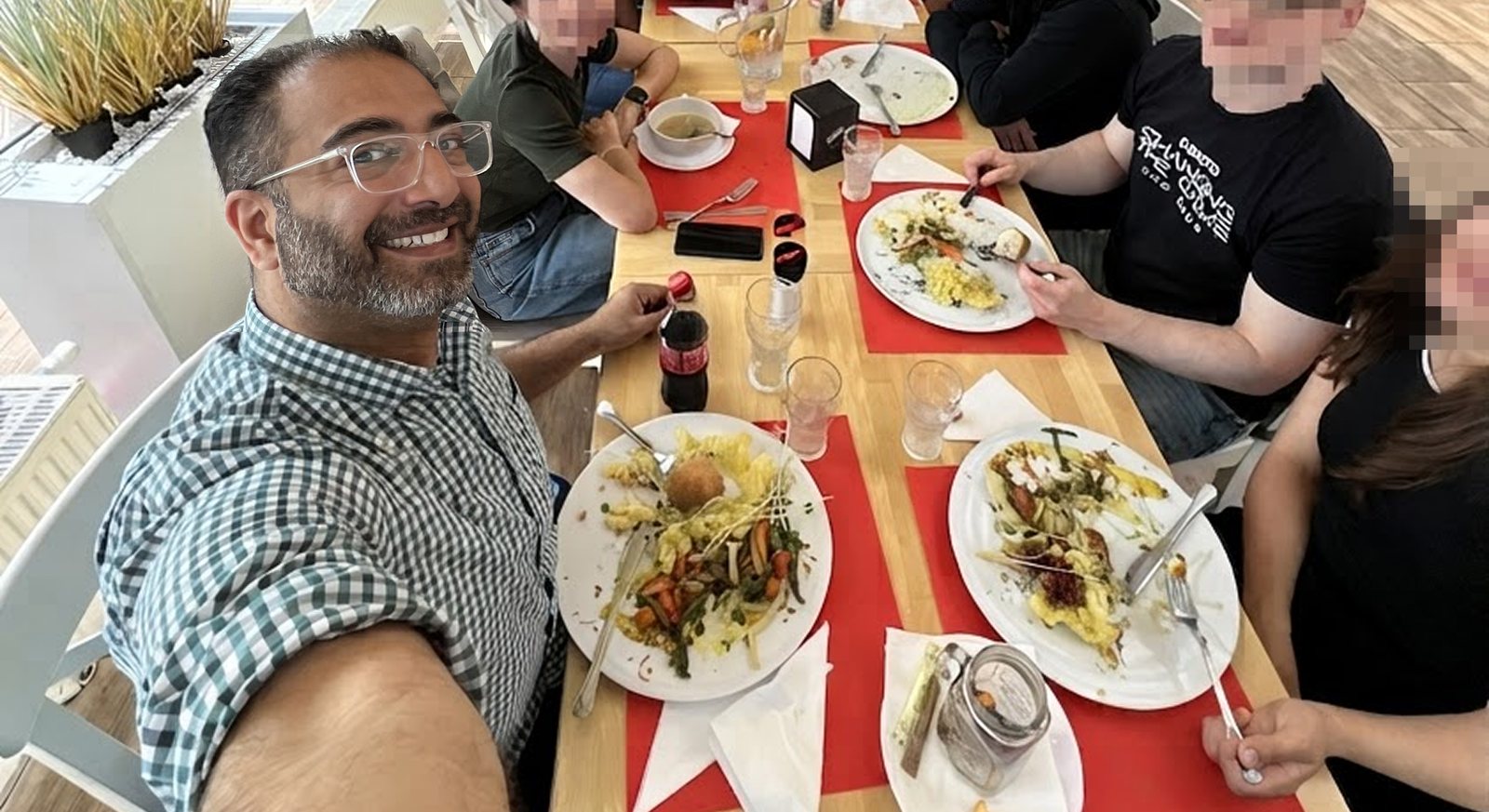 The workshop group sharing a long lunch together after the session, faces blurred